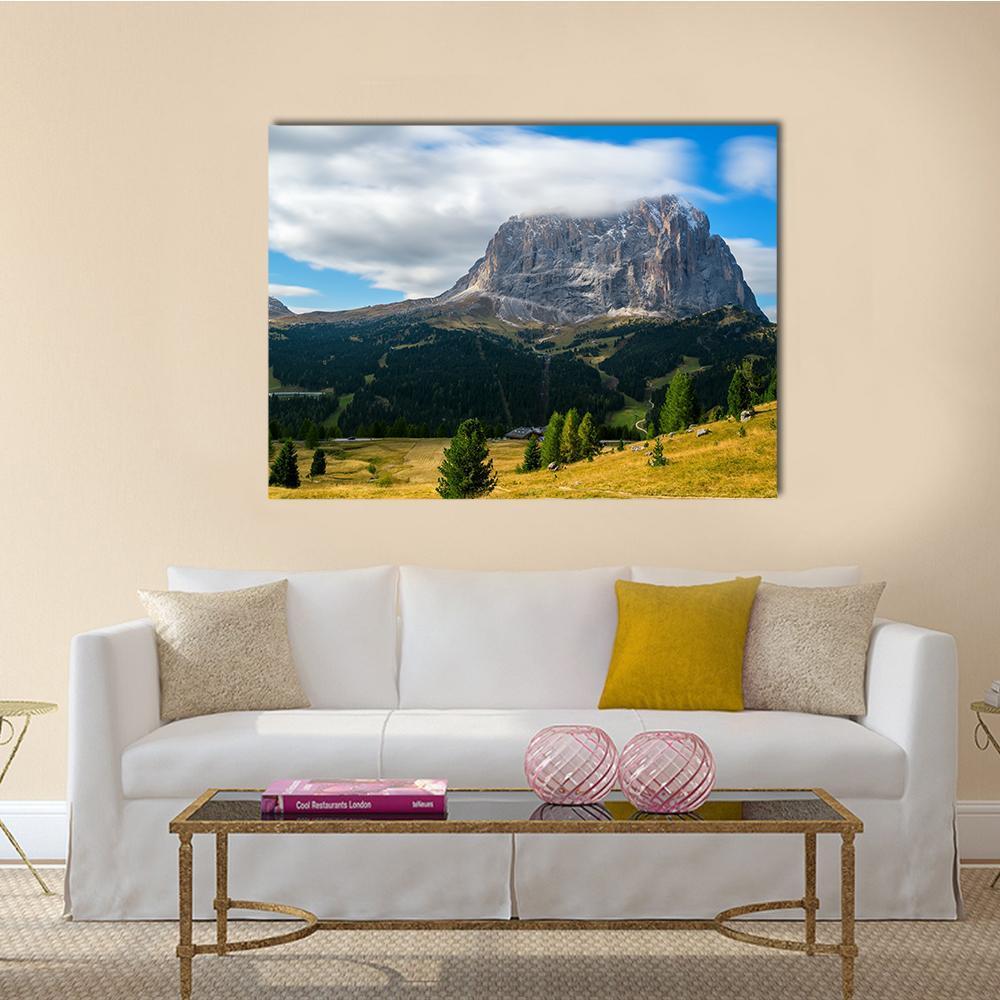 Dolomites Rocky Peak and Meadows Canvas Wall Art in yellow, green and blue, single panel hung on a wall