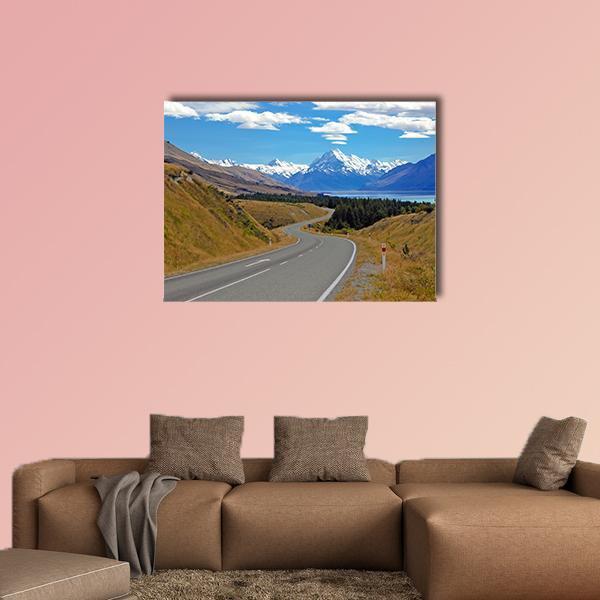 Winding Mountain Road to Snowy Peaks Canvas Wall Art in gray, brown and blue, single panel hung on a wall