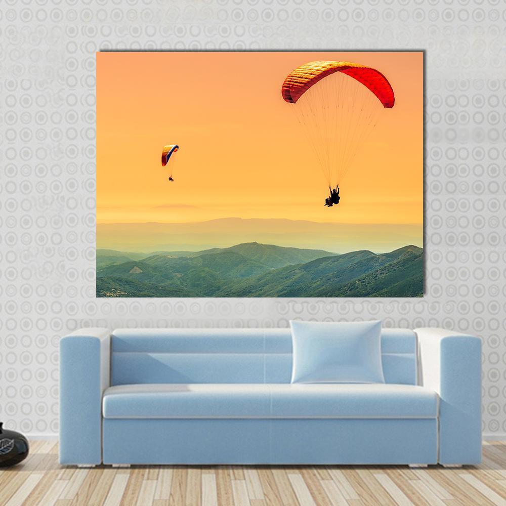 Duo Paragliding at Sunset Canvas Wall Art in orange, yellow and green, single panel hung on a wall