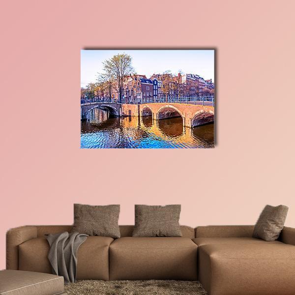 Amsterdam Canal Houses and Bridges Canvas Wall Art in brown, orange and blue, single panel hung on a wall