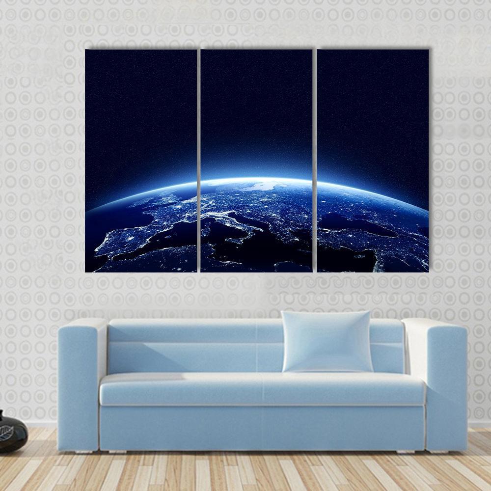 Earth at Night Canvas Wall Art in black and blue, 3 panel horizontal set hung on a wall