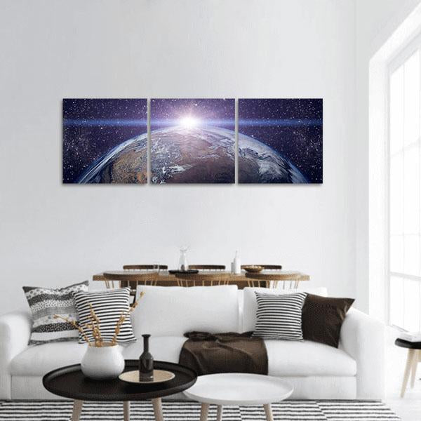Earth from the Cosmos Panoramic Canvas Wall Art in black, blue and purple, hung on a wall
