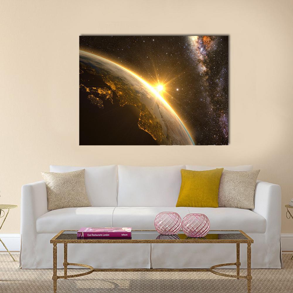 Sunrise Over Earth from Orbit Canvas Wall Art in black, gold and yellow, single panel hung on a wall