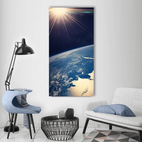 Earth from Space at Sunrise Vertical Canvas Wall Art in black, gold and blue, single vertical panel hung on a wall