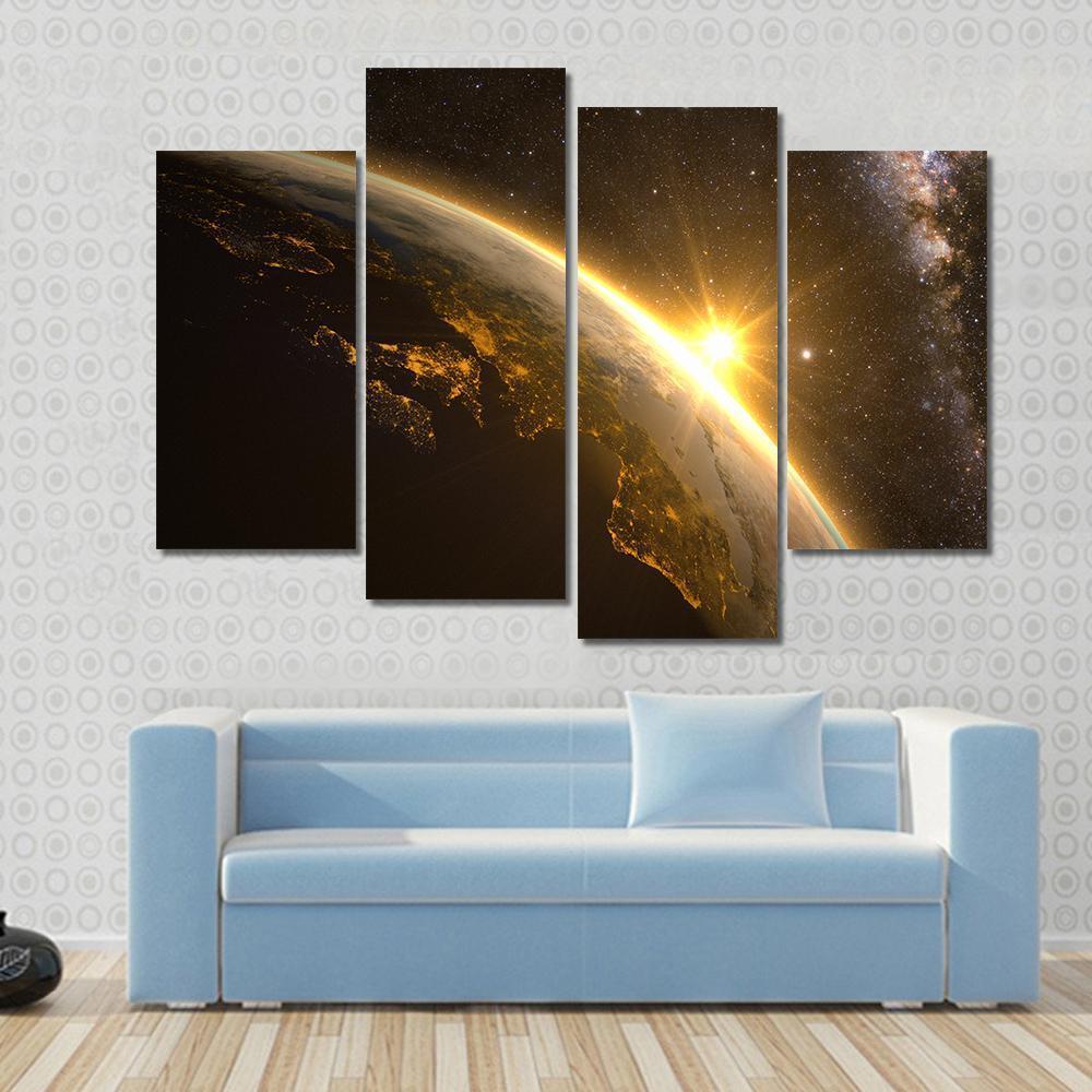 Earth with Spectacular Sunrise Canvas Wall Art in black, orange and yellow, 4 panel Pop layout hung on a wall