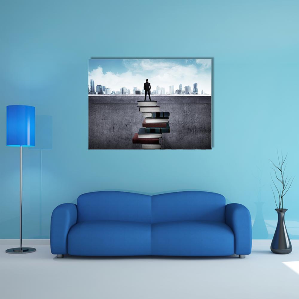 Man Standing on Books Over Cityscape Canvas Wall Art in black, gray and blue, single panel hung on a wall