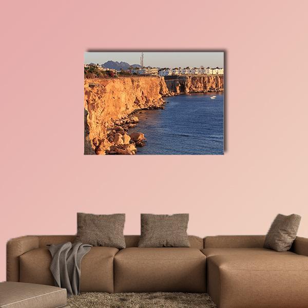 Egyptian Hotel on Red Sea Cliffs Canvas Wall Art in brown, orange and blue, single panel hung on a wall