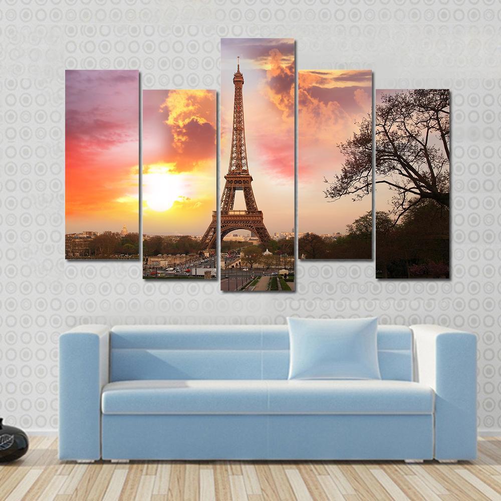Eiffel Tower Against Sunset Canvas Wall Art in orange, yellow and pink, 3 panel horizontal set hung on a wall