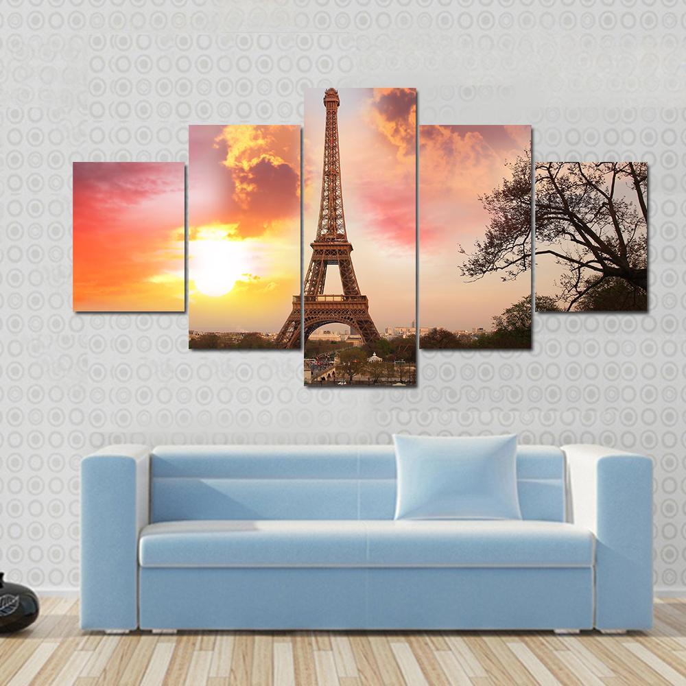 Eiffel Tower Against Sunset Canvas Wall Art in orange, yellow and pink, 3 panel horizontal set hung on a wall