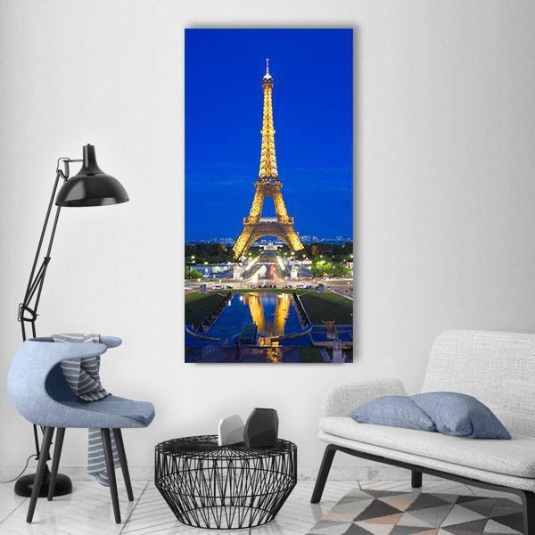 Illuminated Eiffel Tower at Night Vertical Canvas Wall Art in gold, yellow and blue, single vertical panel hung on a wall