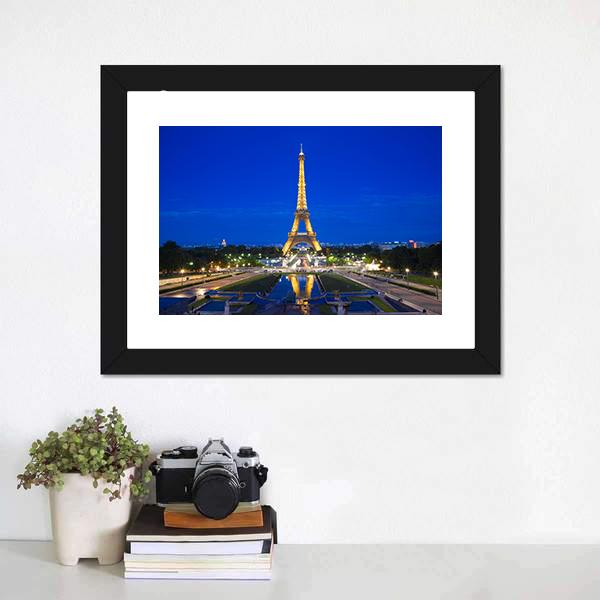 Eiffel Tower Illuminated at Twilight Canvas Wall Art in gold, yellow and blue, hung on a wall