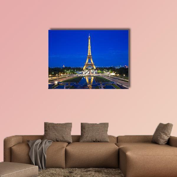 Eiffel Tower Illuminated at Twilight Canvas Wall Art in gold, yellow and blue, single panel hung on a wall