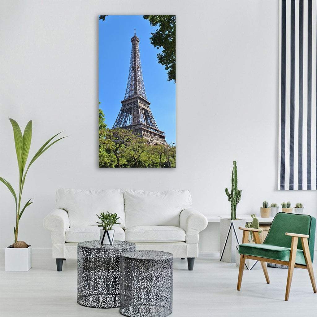 Eiffel Tower in Blue Sky Vertical Canvas Wall Art in green and blue, single vertical panel hung on a wall