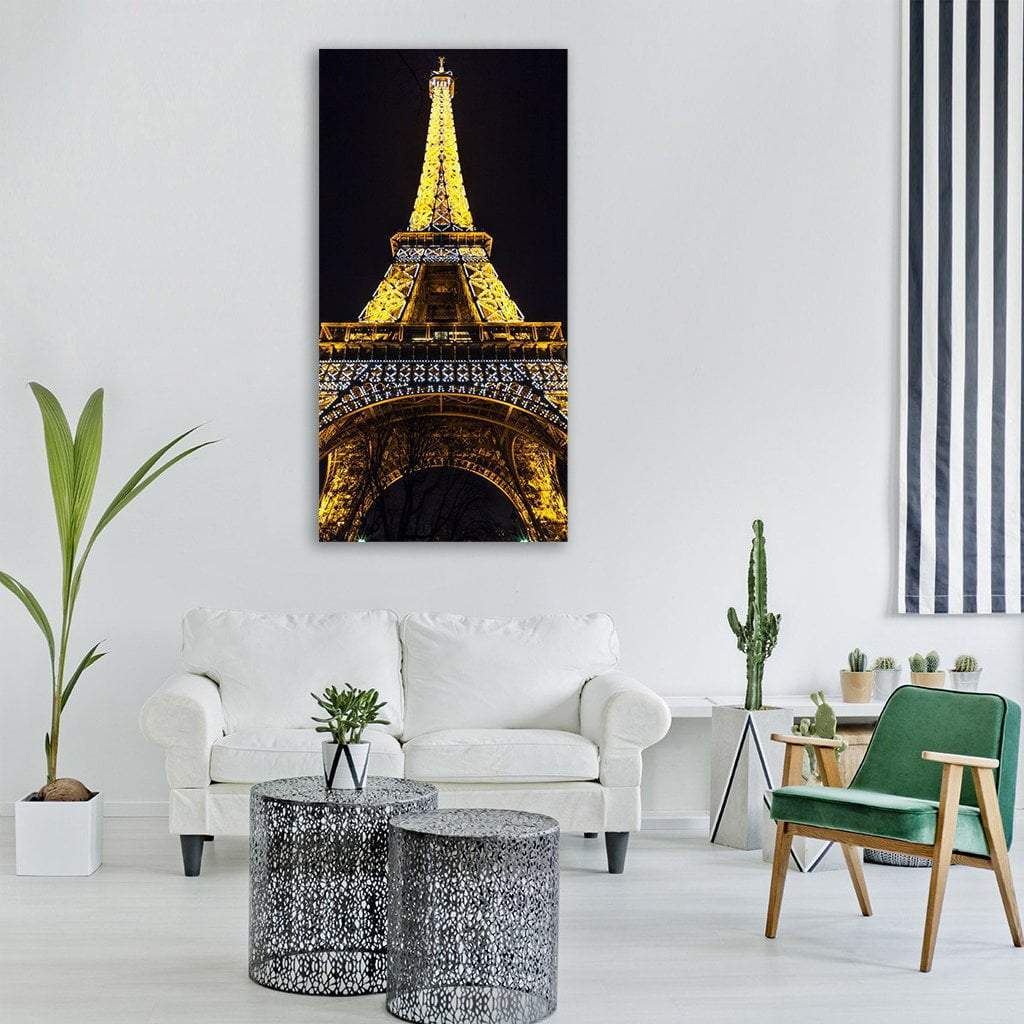 Eiffel Tower at Night Vertical Canvas Wall Art in black, gold and yellow, single vertical panel hung on a wall
