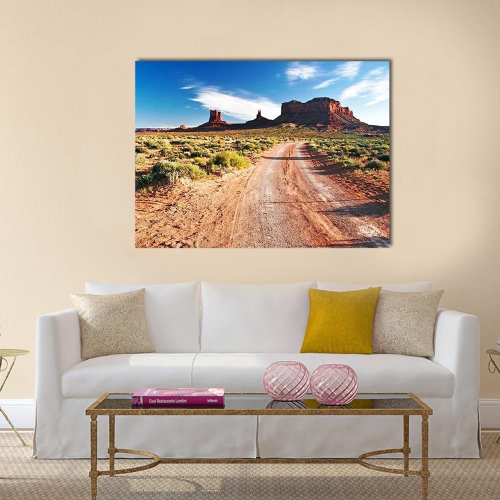 Dirt Road Through Sandstone Mesas Canvas Wall Art in brown, orange and blue, single panel hung on a wall
