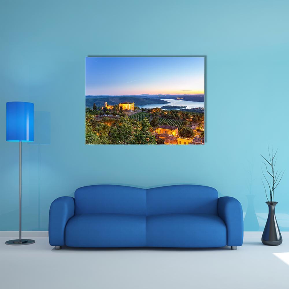 French Village at Twilight Canvas Wall Art in orange, green and blue, single panel hung on a wall