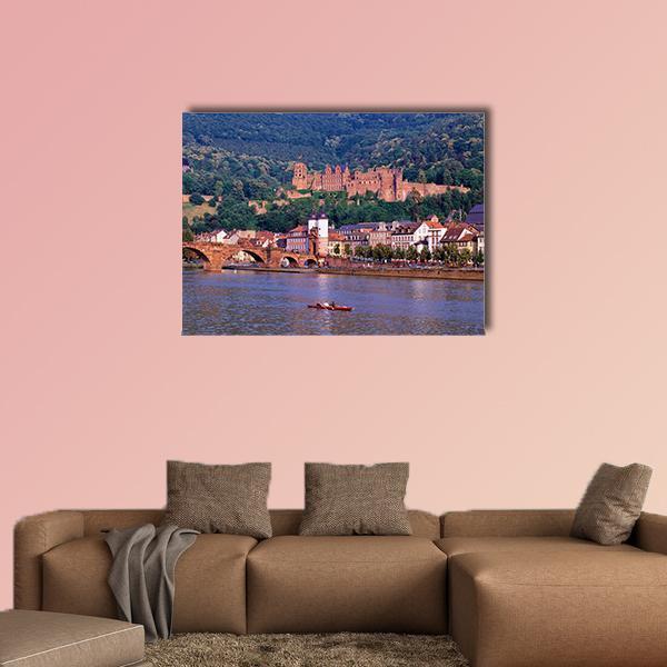 Riverside Castle and Stone Bridge Canvas Wall Art in brown, green and blue, single panel hung on a wall