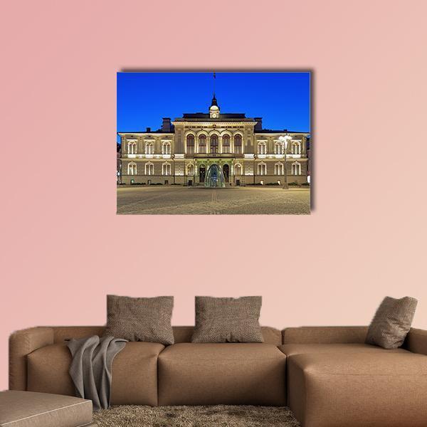 Illuminated City Hall with Fountain Canvas Wall Art in beige, yellow and blue, single panel hung on a wall