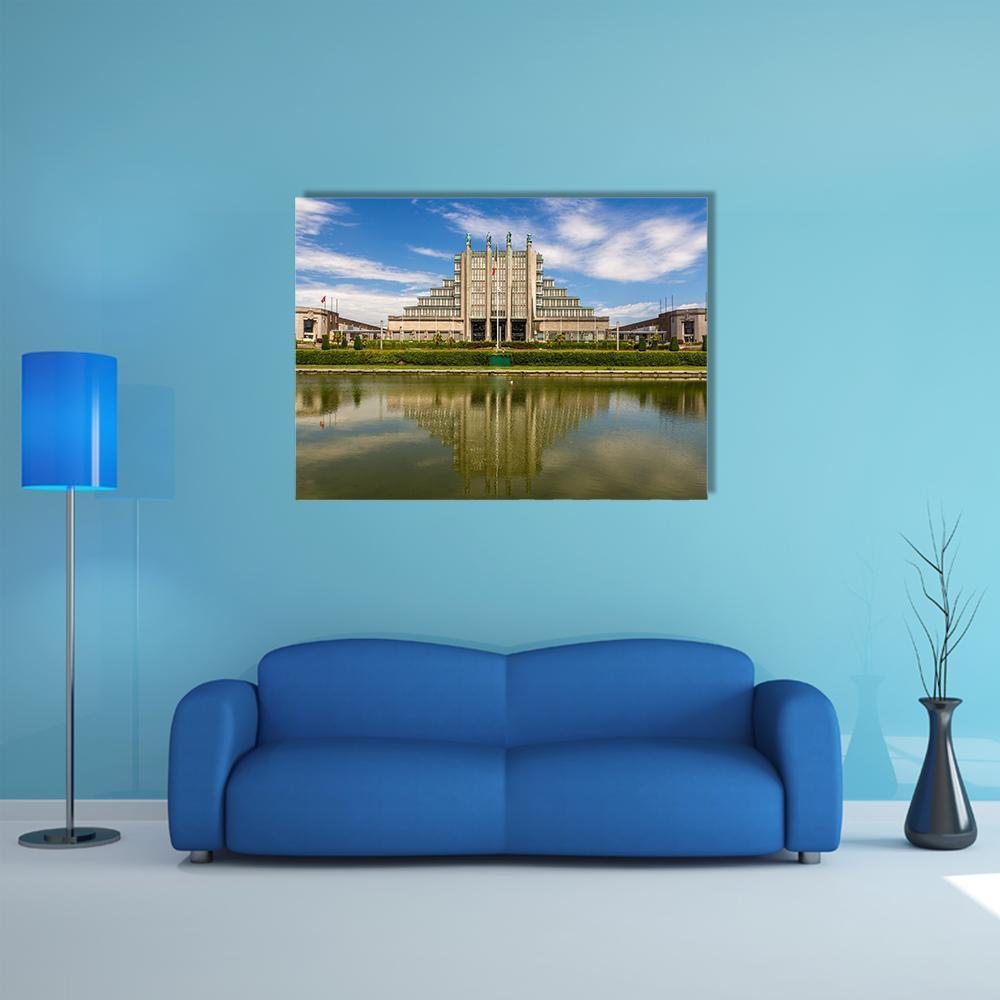 Stepped Exhibition Building with Water Reflection Canvas Wall Art in gray, green and blue, single panel hung on a wall