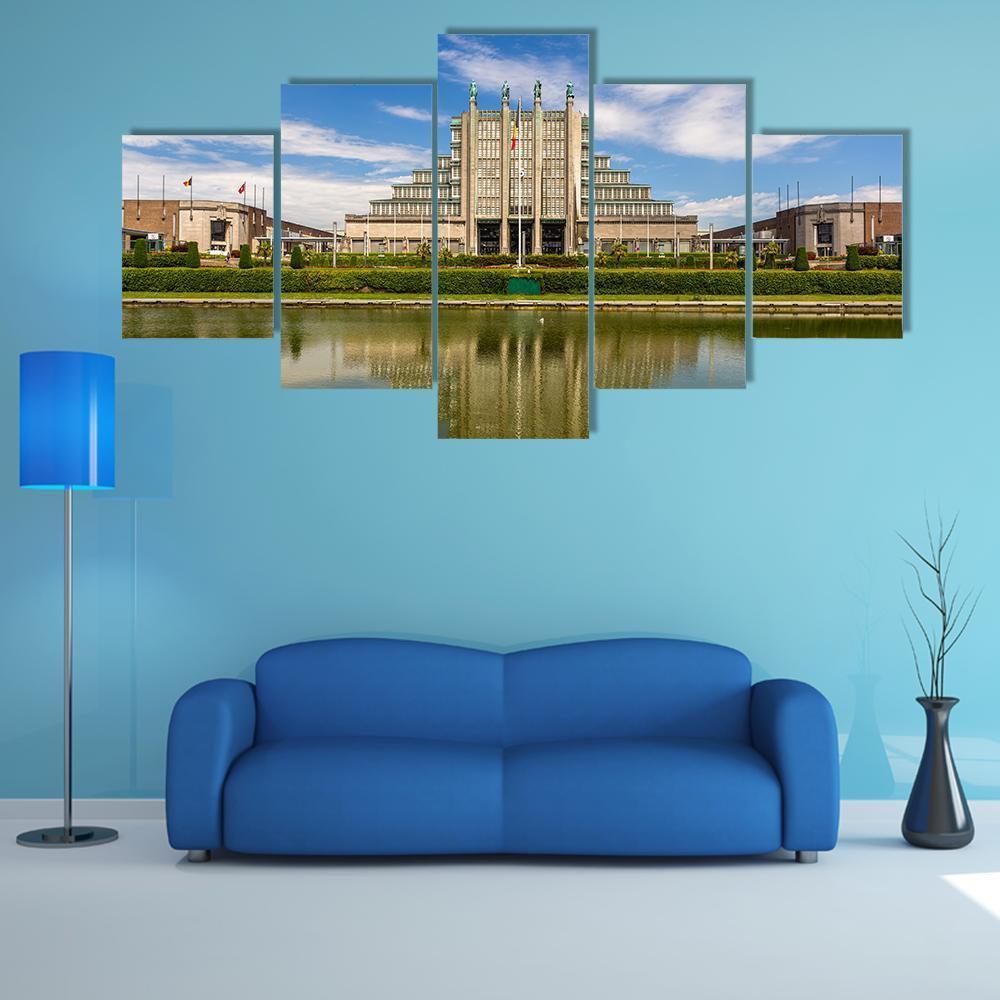 Stepped Exhibition Building with Water Reflection Canvas Wall Art in gray, green and blue, 5 panel Star layout hung on a wall