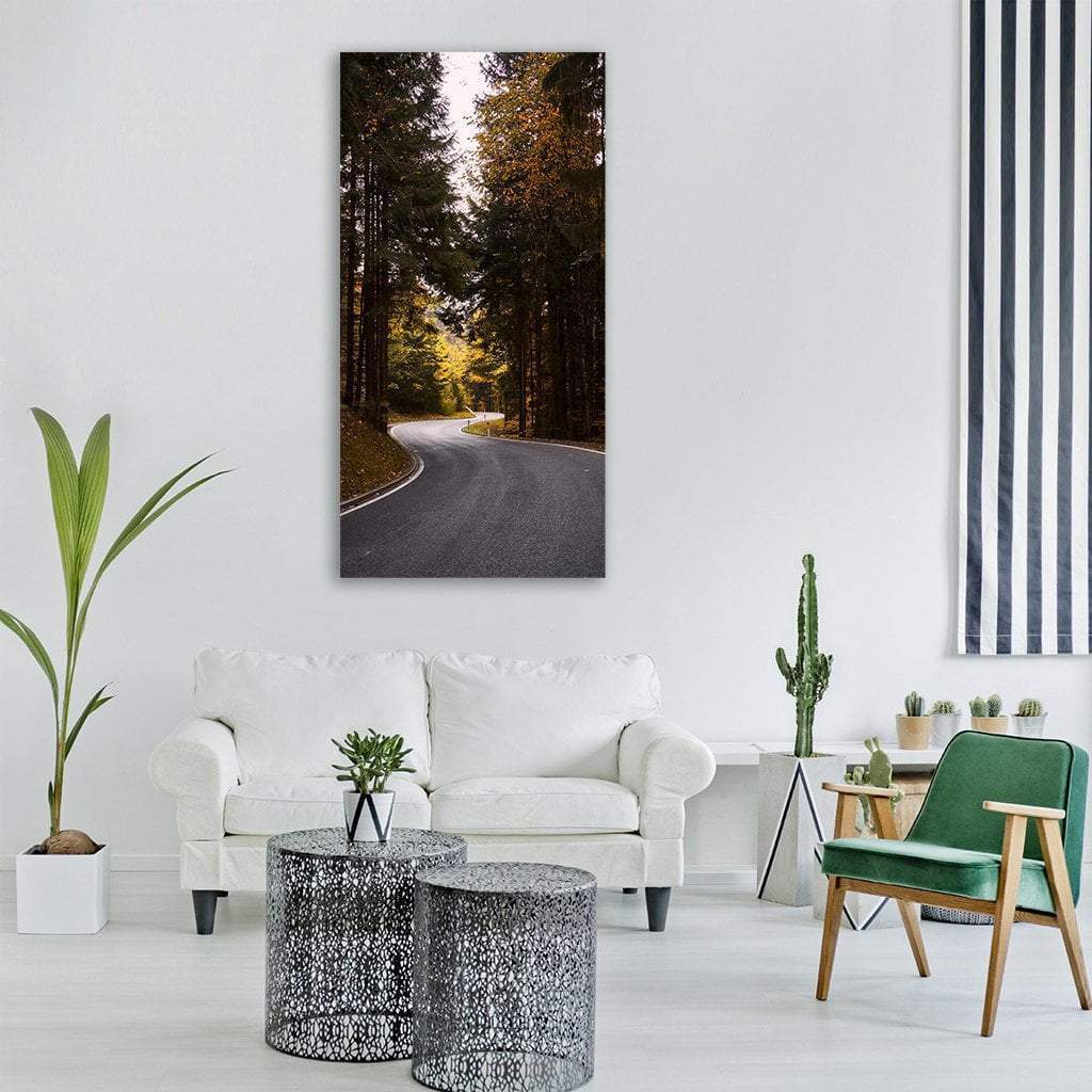Winding Road Through Autumn Forest Vertical Canvas Wall Art in gray, brown and orange, single vertical panel hung on a wall