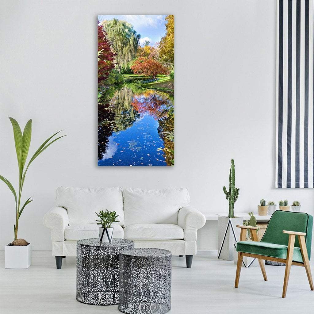 Autumn Lake with Weeping Willow Vertical Canvas Wall Art in orange, green and blue, single vertical panel hung on a wall