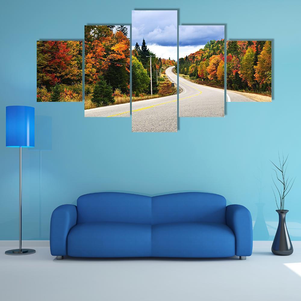 Winding Fall Road Through Autumn Trees Canvas Wall Art in gray, orange and green, 5 panel Star layout hung on a wall