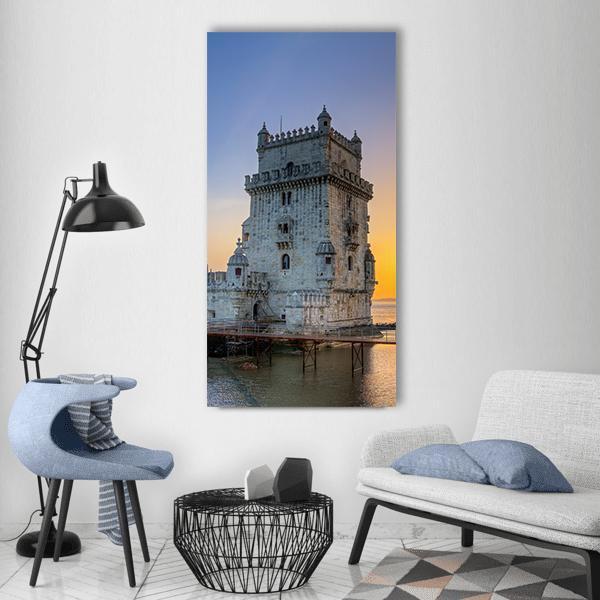 Belém Tower at Sunset Vertical Canvas Wall Art in gray, orange and blue, single vertical panel hung on a wall