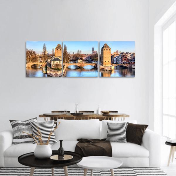 Ponts Couverts Strasbourg River View Panoramic Canvas Wall Art in beige, brown and blue, hung on a wall