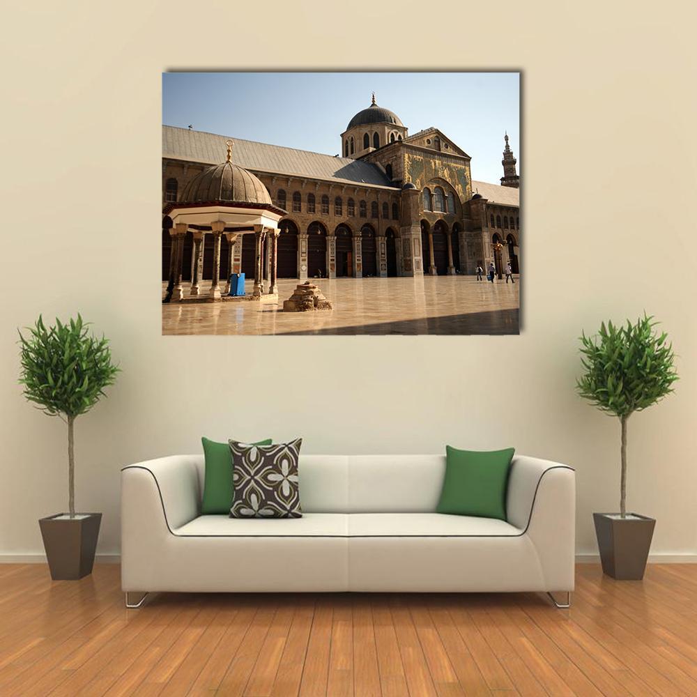 Umayyad Mosque Courtyard with Ornate Facade Canvas Wall Art in beige, brown and blue, single panel hung on a wall