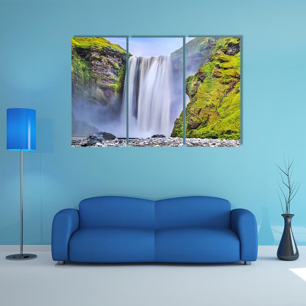 Skógafoss Waterfall with Mossy Rocks Canvas Wall Art in white, gray and green, 3 panel horizontal set hung on a wall