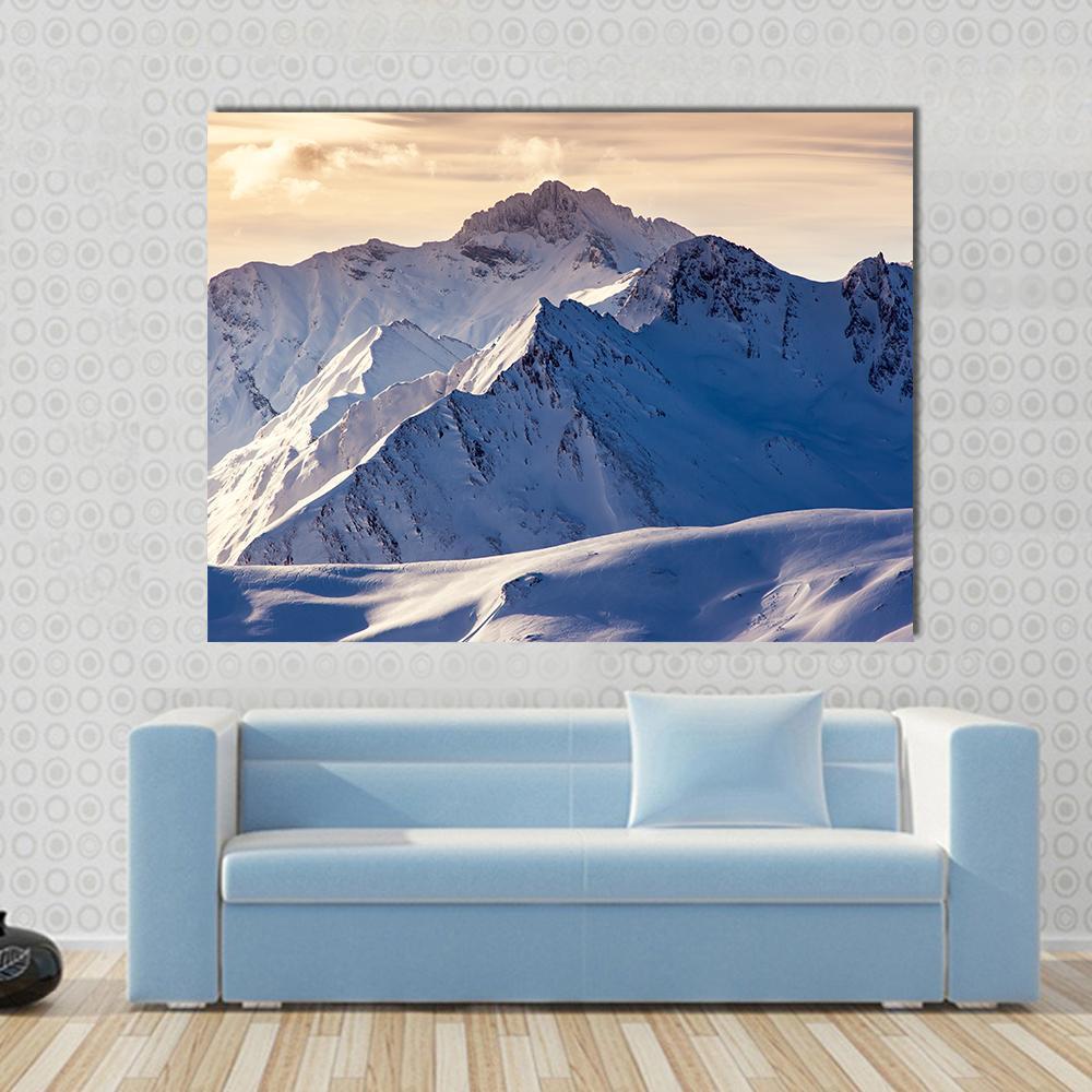 Serene Winter Landscape with Snowy Mountains Canvas Wall Art in white, orange and blue, single panel hung on a wall