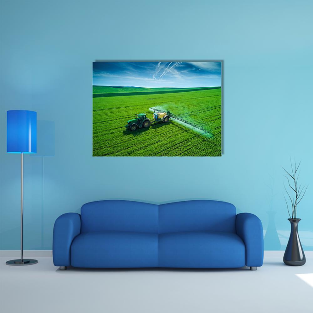 Tractor Spraying a Field Canvas Wall Art in green and blue, single panel hung on a wall