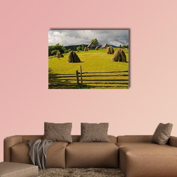 Haystack in Summer Field Canvas Wall Art in gray, yellow and green, single panel hung on a wall