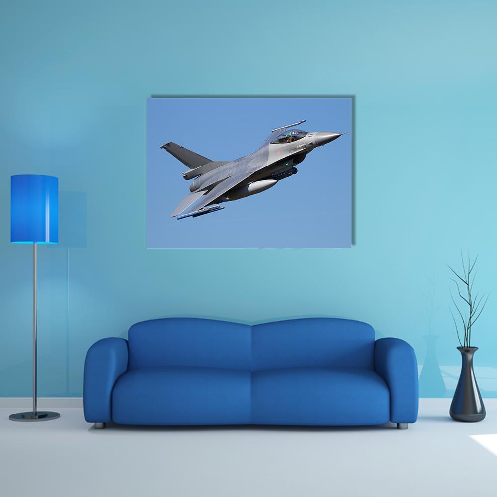 F-16 Fighter Jet Over Blue Sky Canvas Wall Art in gray and blue, single panel hung on a wall