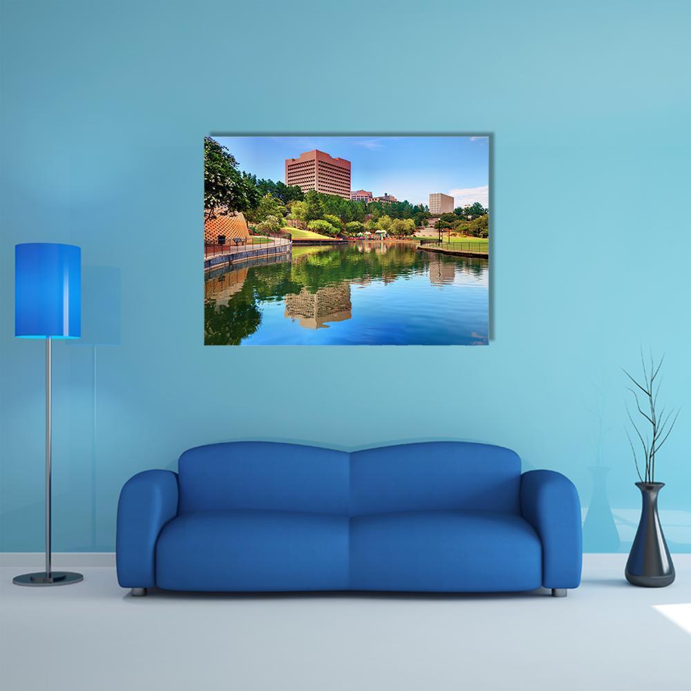 Brick Facade and Lake Reflection Canvas Wall Art in brown, green and blue, single panel hung on a wall