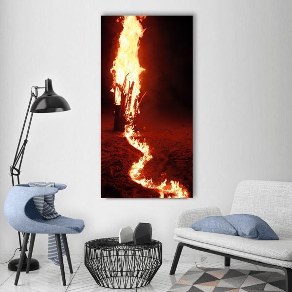 Fire on Beach Sand Vertical Canvas Wall Art in black, orange and yellow, single vertical panel hung on a wall