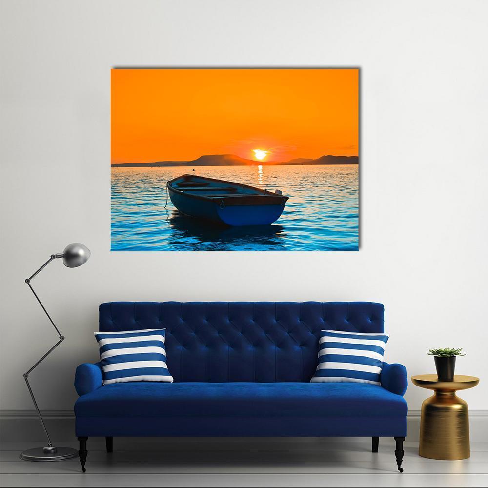 Small Blue Fishing Boat at Sunset Canvas Wall Art in orange and blue, single panel hung on a wall