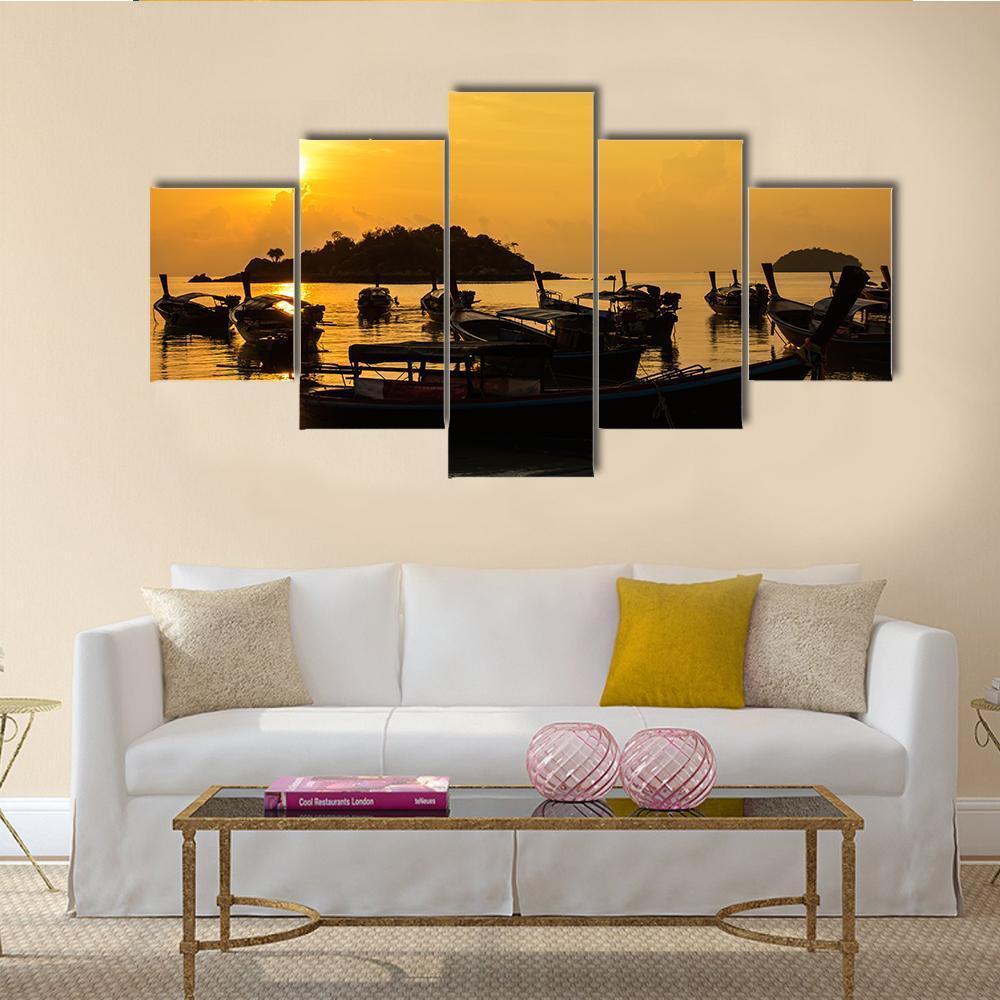Silhouetted Fishing Boats at Sunset Canvas Wall Art in black, orange and yellow, 5 panel Star layout hung on a wall