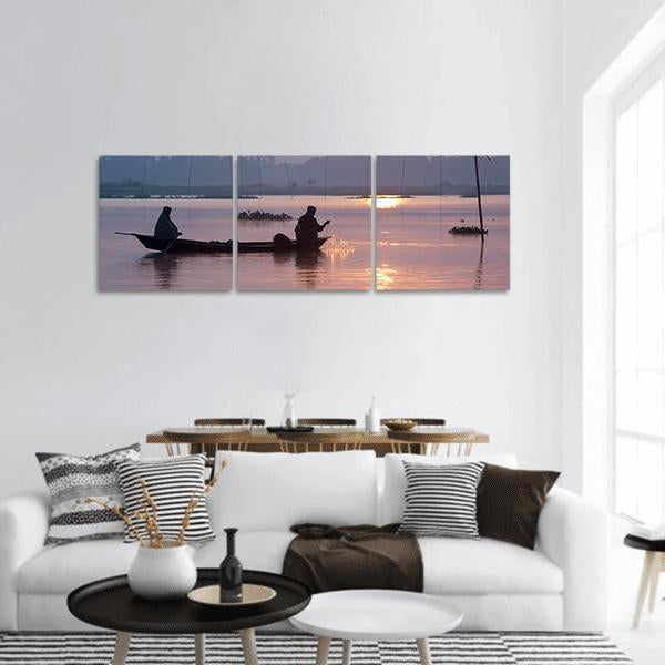 Fishing on Kaliganga River at Sunrise Panoramic Canvas Wall Art in orange, blue and pink, hung on a wall