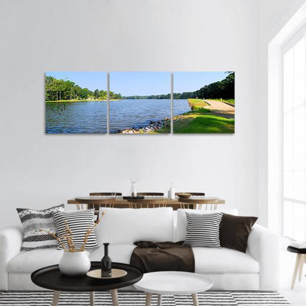 Fishing Lake Summer Landscape Panoramic Canvas Wall Art in green and blue, hung on a wall