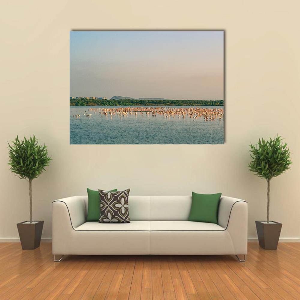 Large Flock of Flamingos on Lake Canvas Wall Art in beige, blue and pink, single panel hung on a wall