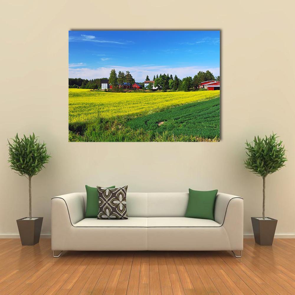 Red Barn in a Yellow Field, Finland Canvas Wall Art in yellow, green and blue, single panel hung on a wall