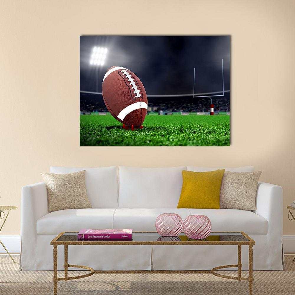 Football on Green Field Canvas Wall Art in black, brown and green, single panel hung on a wall