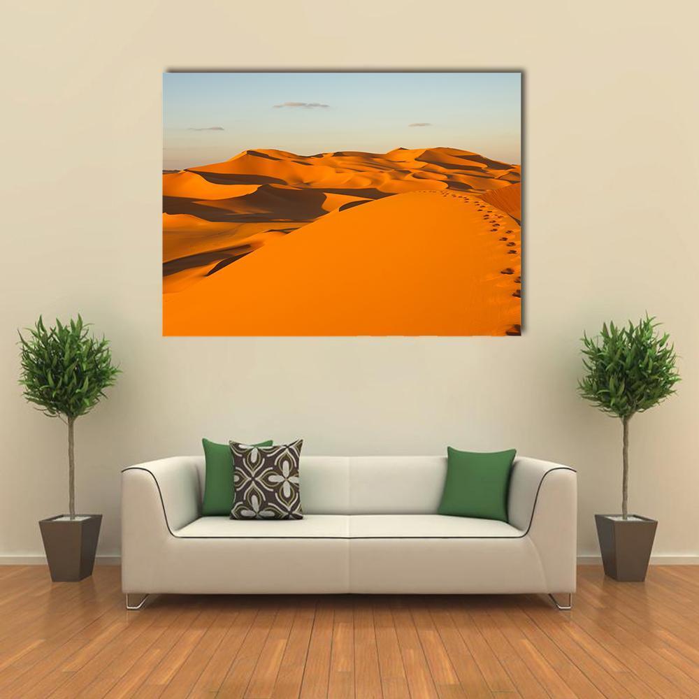 Footprints in Sand Dunes Canvas Wall Art in orange, yellow and blue, single panel hung on a wall