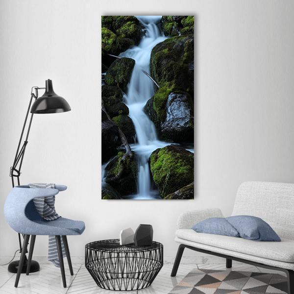 Moss-covered Forest Waterfall Vertical Canvas Wall Art in black, white and green, single vertical panel hung on a wall