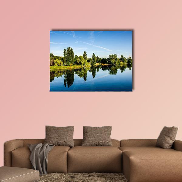 Forest by the Lake Canvas Wall Art in green and blue, single panel hung on a wall