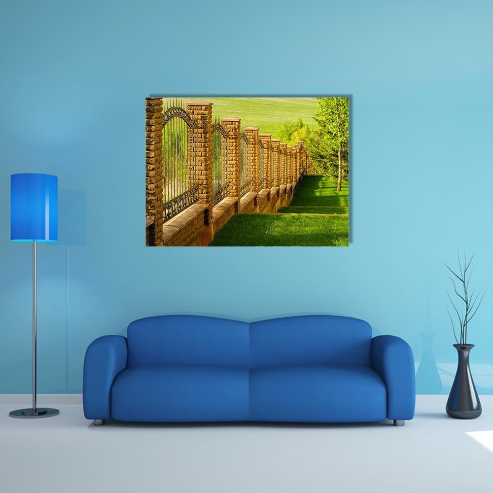 Wrought Iron Gate with Brick Posts Canvas Wall Art in brown, yellow and green, single panel hung on a wall