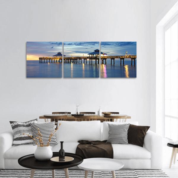 Fort Myers Pier at Dusk Panoramic Canvas Wall Art in orange, yellow and blue, hung on a wall