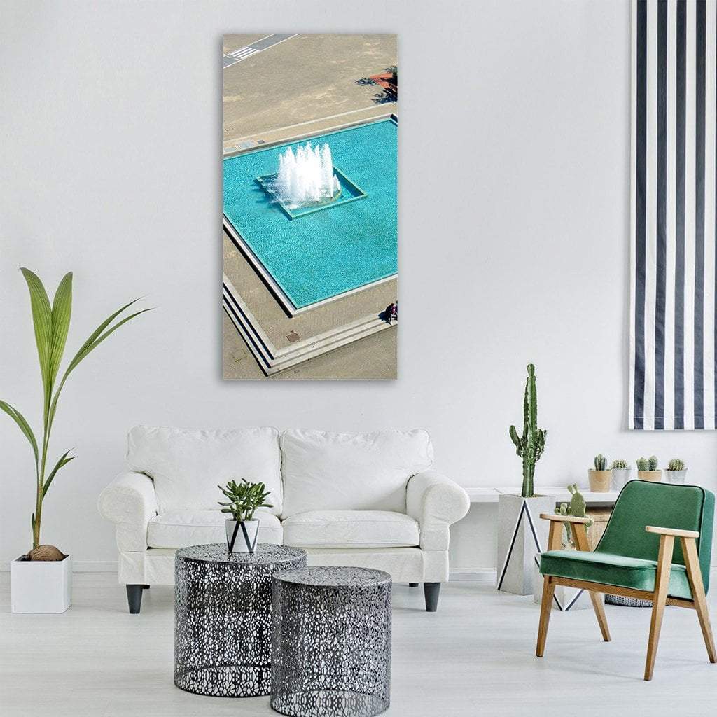 Aerial Turquoise Fountain Over Rectangular Pool Vertical Canvas Wall Art in gray, beige and blue, single vertical panel hung on a wall